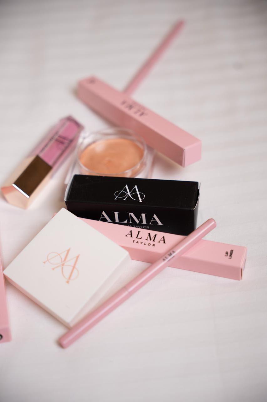 The full ALMA collection laid out including lip products, packaging and compact