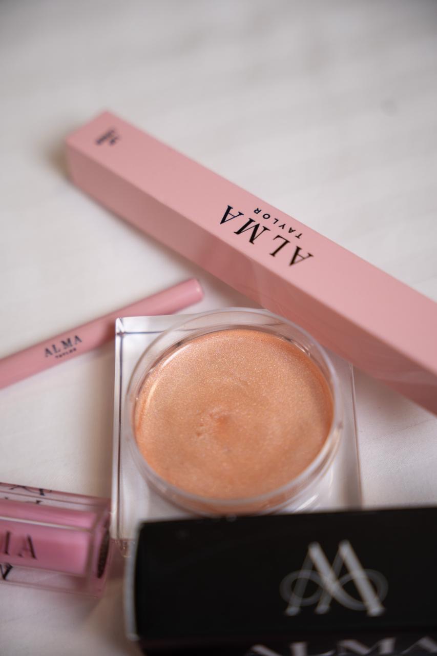ALMA Body Glow Cream in a clear jar beside ALMA packaging